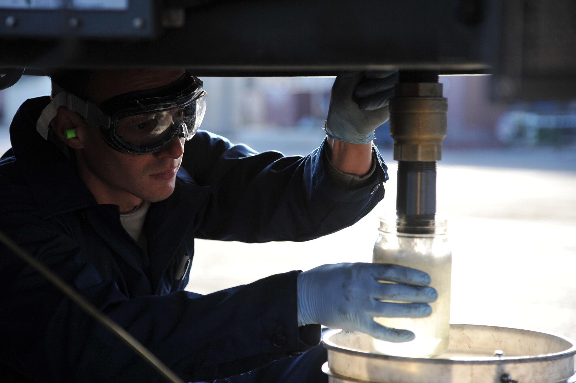 Airman Joseph Bagnasco, 56th LRS POL refueling maintenance technician, drains the rear sump to the lowest level in the fuel tank and checks for water and debris. (U.S. Air Force photo/Senior Airman Sandra Welch)