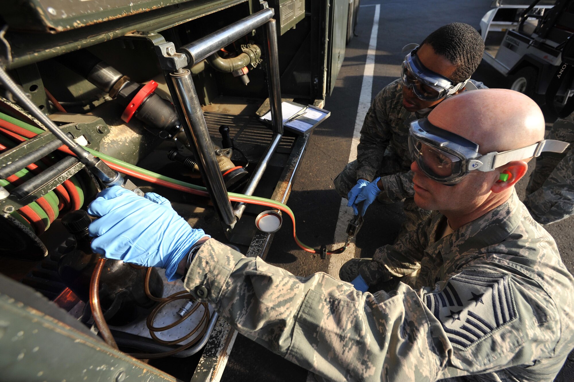 Chief Master Sgt. David Staton, 56th Fighter Wing command chief, and Staff Sgt. Kelvin Barnes, 56th LRS POL fuels lab NCO-in-charge, take a fuel sample for lab testing. (U.S. Air Force photo/Senior Airman Sandra Welch)