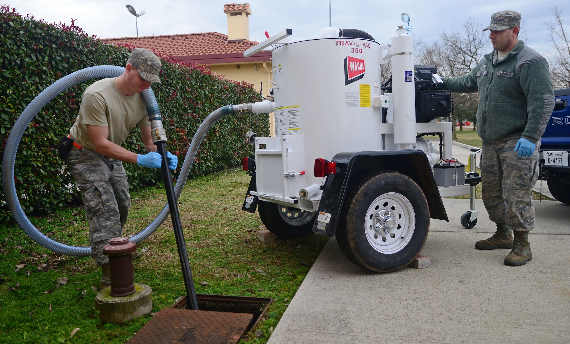 Airman 1st Class David Krenning (left) and Airman 1st Class Anthony Boe, 31st Civil Engineer Squadron water and fuel systems maintenance journeymen, vacuum waste from a grease trap using the Trav-L-Vac 300 Feb. 14, 2013, at Aviano Air Base, Italy. Krenning and Boe are also in charge of water distribution and fire suppression/fuel systems for the firefighters. (U.S. Air Force photo/Airman 1st Class Matthew Lotz)
