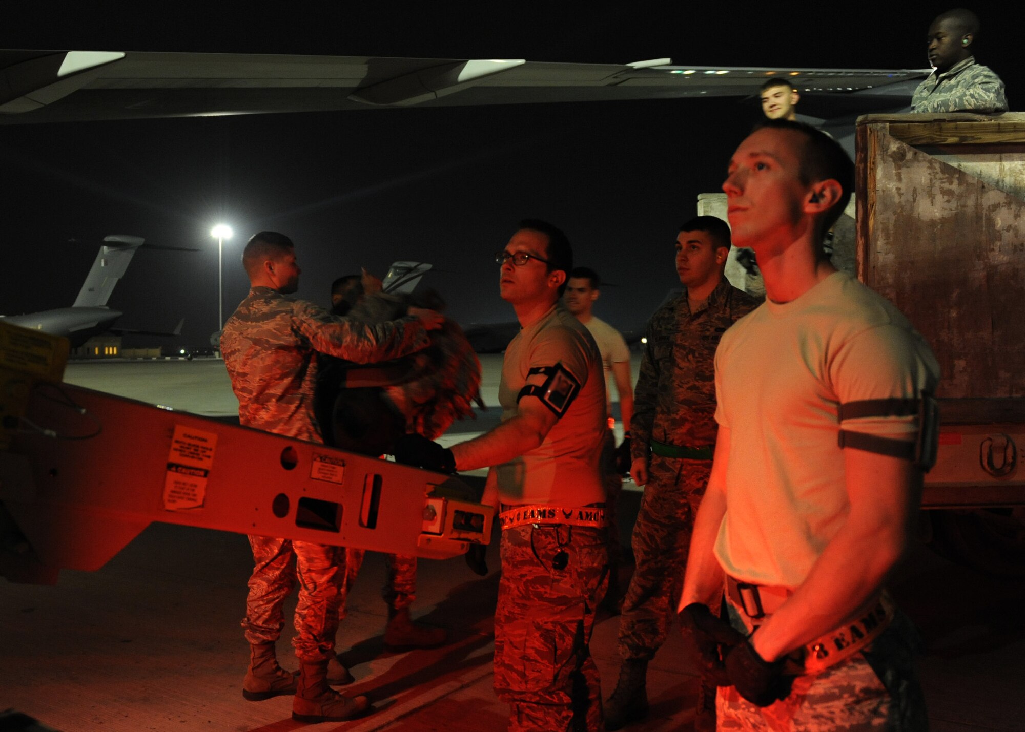 SOUTHWEST ASIA – Staff Sgt. Zachary Folk (right) supervises while Airman 1st Class Daniel Hodge (center) directs luggage unloaded off the aircraft to the volunteer baggage detail Feb. 27. Both Airmen are assigned to the 8th Expeditionary Air Mobility Squadron. After the plane downloads passengers and baggage, the 8th EAMS team assists loading all outbound passengers. In the past year the air terminal processed more than 90,000 passengers on more than 10,250 missions. (U.S. Air Force photo/Senior Airman Joel Mease