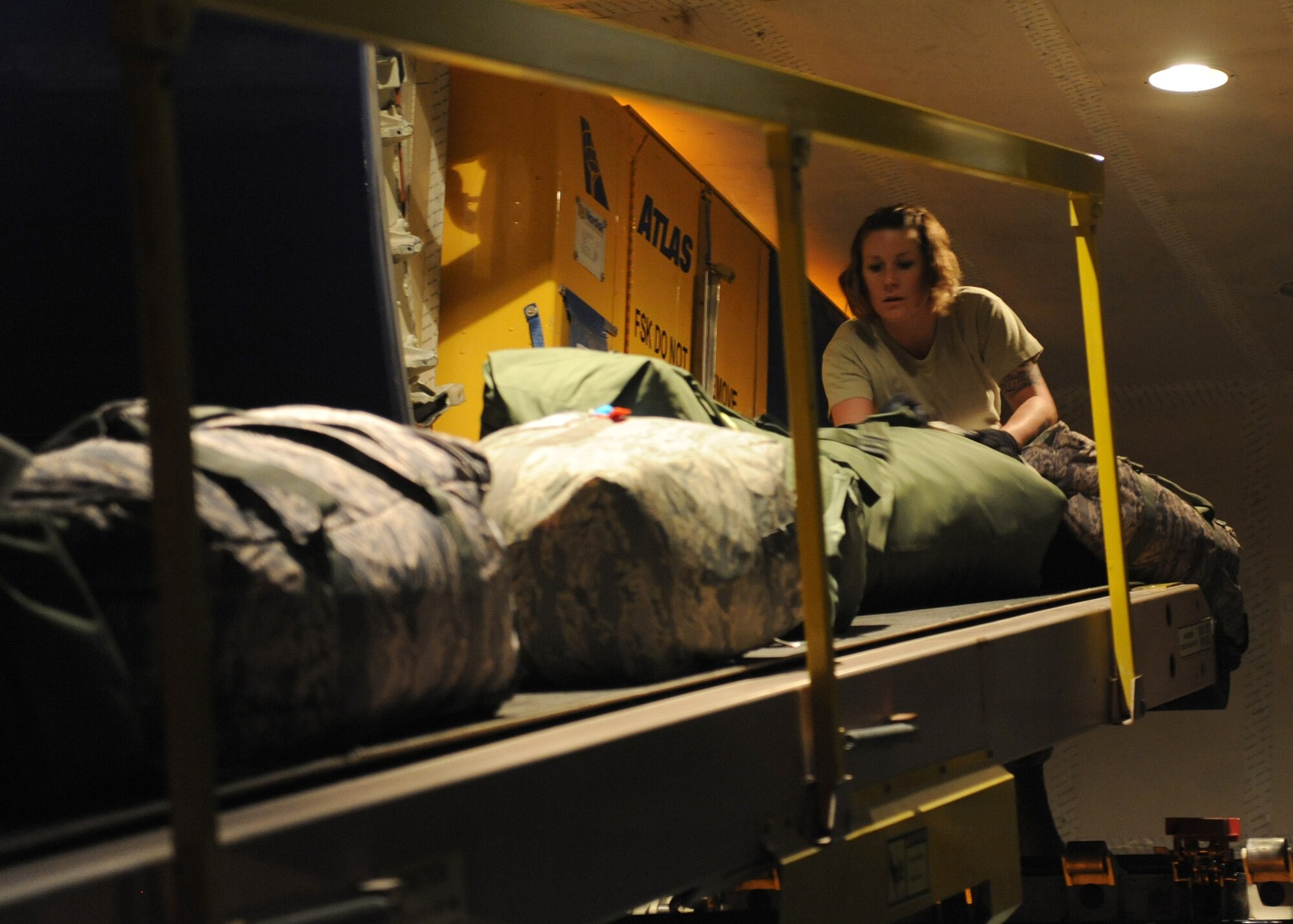 SOUTHWEST ASIA – Airman 1st Class Genny Martin, 8th Expeditionary Air Mobility Squadron, unloads baggage from a plane that just landed Feb. 27. A full download with several hundred passengers takes approximately a little more than three hours. Martin is deployed from the 721st Aerial Port Squadron at Ramstein Air Base, Germany. (U.S. Air Force photo/Senior Airman Joel Mease)