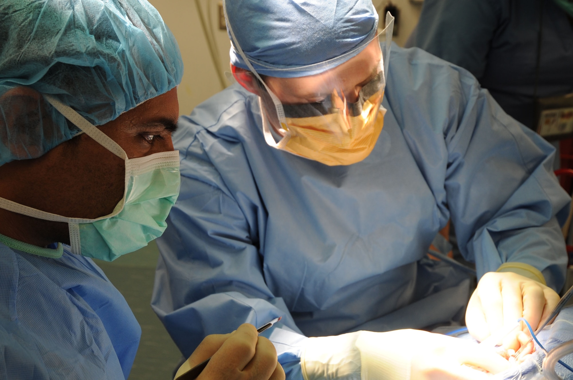 1st Lt. (Dr.) Farooq Azam, Afghan National Police, and Maj. (Dr.) Peter Sabatini, 455th Expeditonary Medical Group surgeon, perform a biopsy operation at the Craig Joint Theater Hospital on Bagram Airfield, Afghanistan, Feb. 24, 2013. Azam is a participant in the Afghan Trauma Mentorship Program, which brings Afghan doctors and surgeons to the CJTH to learn about the latest medical equipment and techniques. (U.S. Air Force photo/Staff Sgt. David Dobrydney)