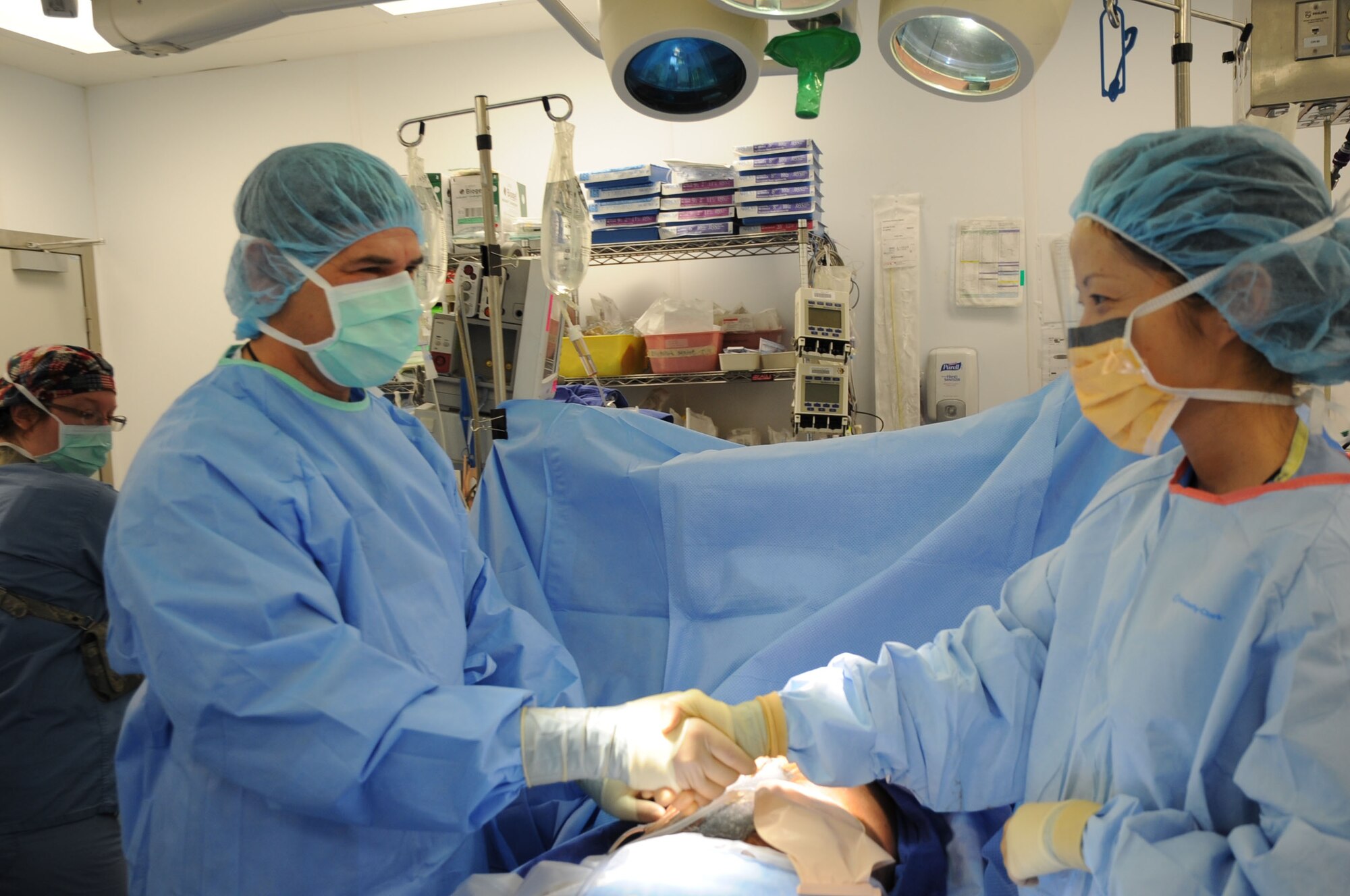 Capt. (Dr.) Mujib-ul-Rahman Amin of the Afghan National Army shakes hands with Maj. (Dr.) Fia Yi, 455th Expeditionary Medical Group surgeon, after successfully completing an operation at the Craig Joint Theater Hospital on Bagram Airfield, Afghanistan, Feb. 24, 2013. Amin is part of the Afghan Trauma Mentorship Program, which brings Afghan doctors and surgeons to the CJTH to learn about the latest medical equipment and techniques. (U.S. Air Force photo/Staff Sgt. David Dobrydney)
