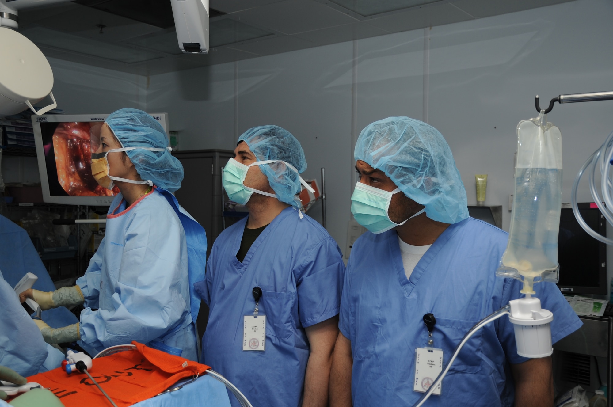 Two participants in the Afghan Trauma Mentorship Program observe an operation at the Craig Joint Theater Hospital on Bagram Airfield, Afghanistan, Feb. 14, 2013. The program invites Afghan doctors and nurses to learn about the latest medical techniques and equipment. (U.S. Air Force photo/Staff Sgt. David Dobrydney)