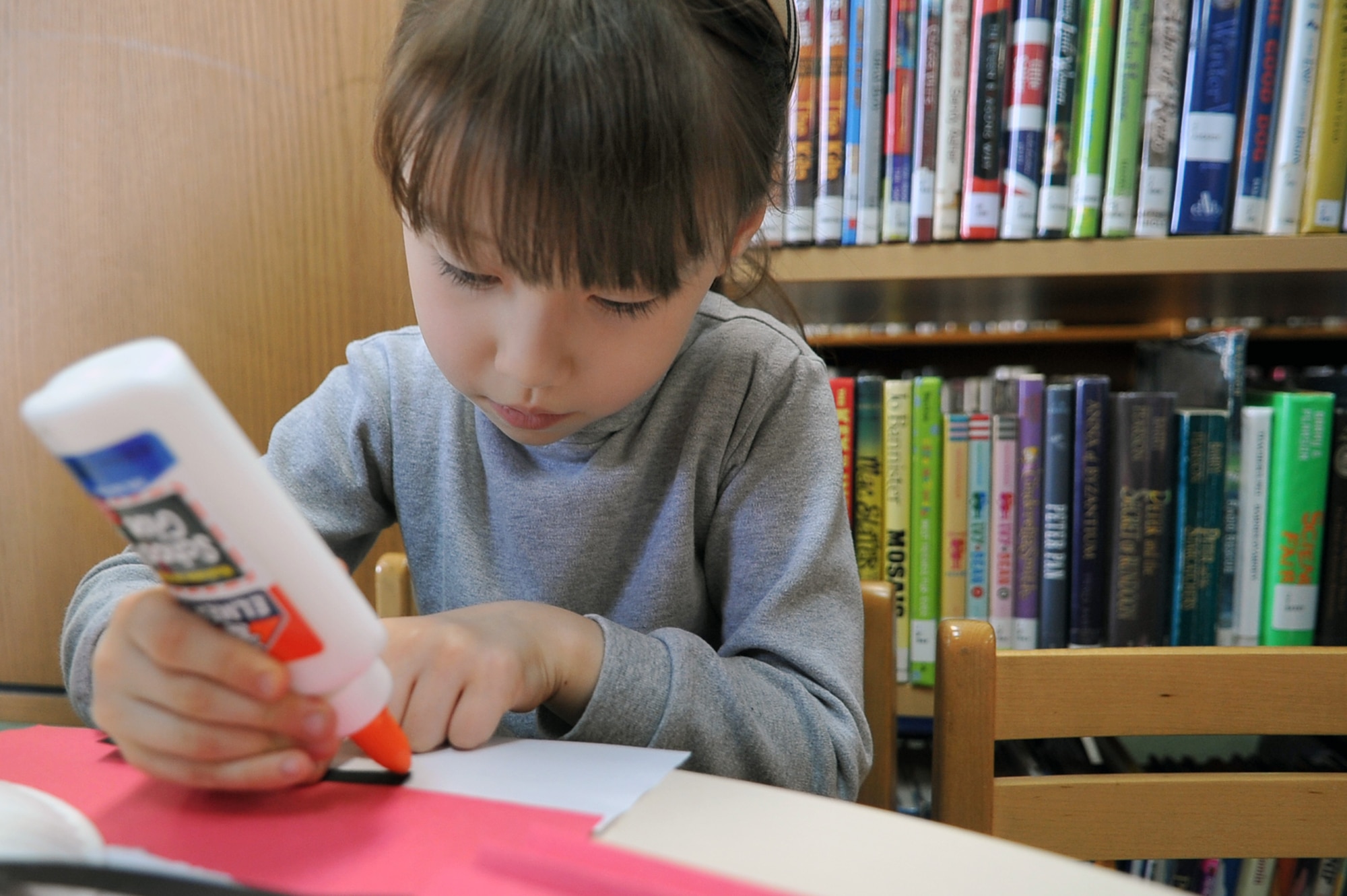 Abigail Rocker, 5, glues together red and white paper to create a her mask inspired by Dr. Suess’ “Cat in the Hat” as part of Osan Library’s Dr. Seuss birthday celebration at Osan Air Base, Republic of Korea, Feb. 28, 2013. The children constructed masks and other Dr. Seuss’ books inspired crafts. (U.S. Air Force photo/Airman 1st Class Alexis Siekert)