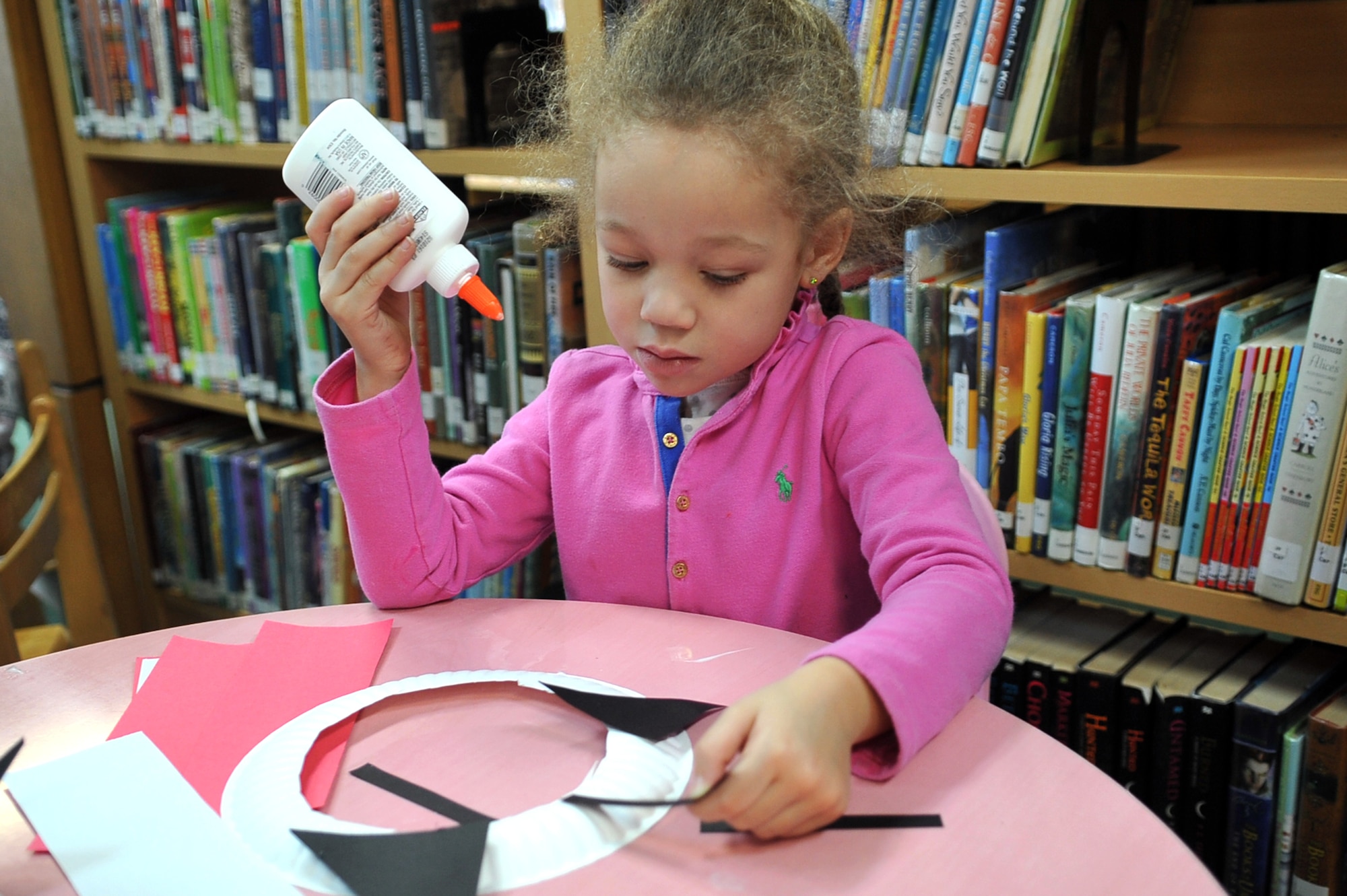 Gillian-Rose Hagarty, 4, glues whiskers to her mask inspired by Dr. Suess’ “Cat in the Hat” as part of Osan Library’s Dr. Seuss birthday celebration at Osan Air Base, Republic of Korea, Feb. 28, 2013. Children from around Osan came together for story time inspired by the famous children’s author. (U.S. Air Force photo/Airman 1st Class Alexis Siekert)