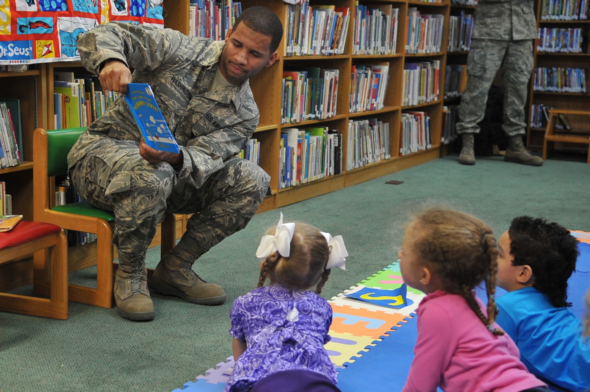 Senior Airman Joseph Washington, 51st Aerospace Medicine Squadron Bioenvironmental Engineering technician, reads “And to Think I saw it on Mulberry Street” by Dr. Seuss as part of the Osan Library’s Dr. Seuss birthday celebration at Osan Air Base, Republic of Korea, Feb. 28, 2013. “And to Think I Saw it on Mulberry Street,” was Seuss’ first published book. (U.S. Air Force photo/Airman 1st Class Alexis Siekert)