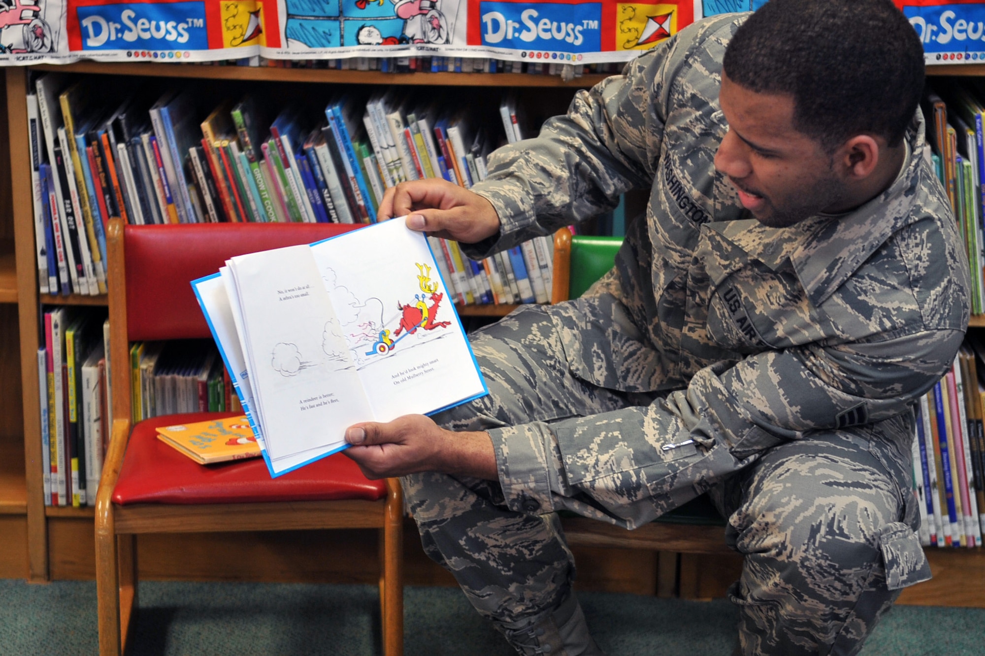 Senior Airman Joseph Washington, 51st Aerospace Medicine Squadron Bioenvironmental Engineering technician, reads “And to Think I saw it on Mulberry Street” by Dr. Seuss as part of the Osan Library’s Dr. Seuss birthday celebration at Osan Air Base, Republic of Korea, Feb. 28, 2013. “And to Think I Saw it on Mulberry Street,” was Seuss’ first published book. (U.S. Air Force photo/Airman 1st Class Alexis Siekert)