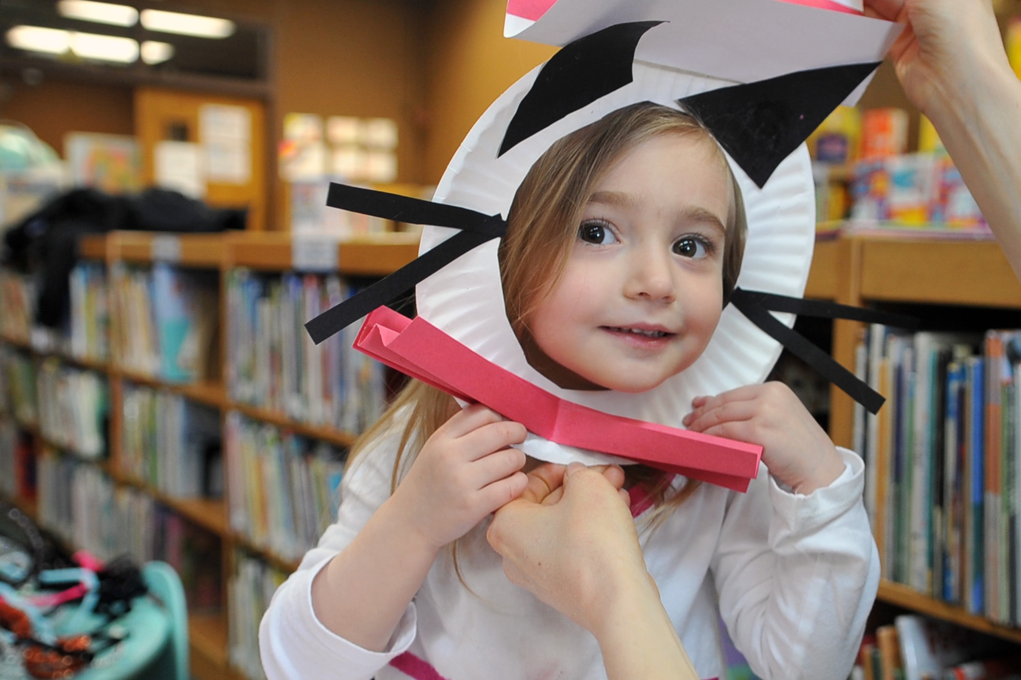 Ellora Mahajam, 2.5, tries out her new mask inspired by Dr. Suess’ “Cat in the Hat” as part of Osan Library’s Dr. Seuss birthday celebration at Osan Air Base, Republic of Korea, Feb. 28, 2013. After Dr. Seuss story time, the children constructed masks and other Dr. Seuss’ books inspired crafts. (U.S. Air Force photo/Airman 1st Class Alexis Siekert)