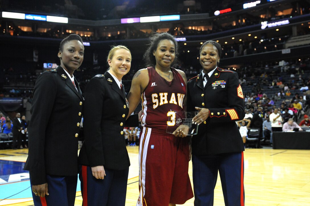 CHARLOTTE, N.C.— GySgt Tawanda Hanible, Capt. Martha MacPhee, and CWO2 Alaina Olenderski present the Women’s Leadership Award to Taylor Dalrymple, a forward for the Shaw University Women’s Basketball Team, moments after their victory against Fayetteville State University during the finals of The Central Intercollegiate Athletic Association (CIAA),  hosted at the Time Warner Cable Arena in Charlotte, N.C., March 02, 2013. The CIAA was founded in 1912 as the Colored Intercollegiate Athletic Association, and is the oldest African-American athletic conference in the Nation. The CIAA is touted as being the third most attended basketball tournament among all NCAA divisions, and consists of Historically Black Colleges and Universities (HBCU) spanning the East Coast from Pennsylvania to North Carolina. The 2013 CIAA Tournament is expected to bring about 190,000 fans to Charlotte, N.C., during the course of the week with an economic impact exceeding $40 million. Marines from across the Nation were brought to Charlotte during the 2013 CIAA tournament to raise awareness of the Marine Corps' Officer programs to the participants and attendees of the tournament as a viable option for college graduates after they transition from college to professional life.
