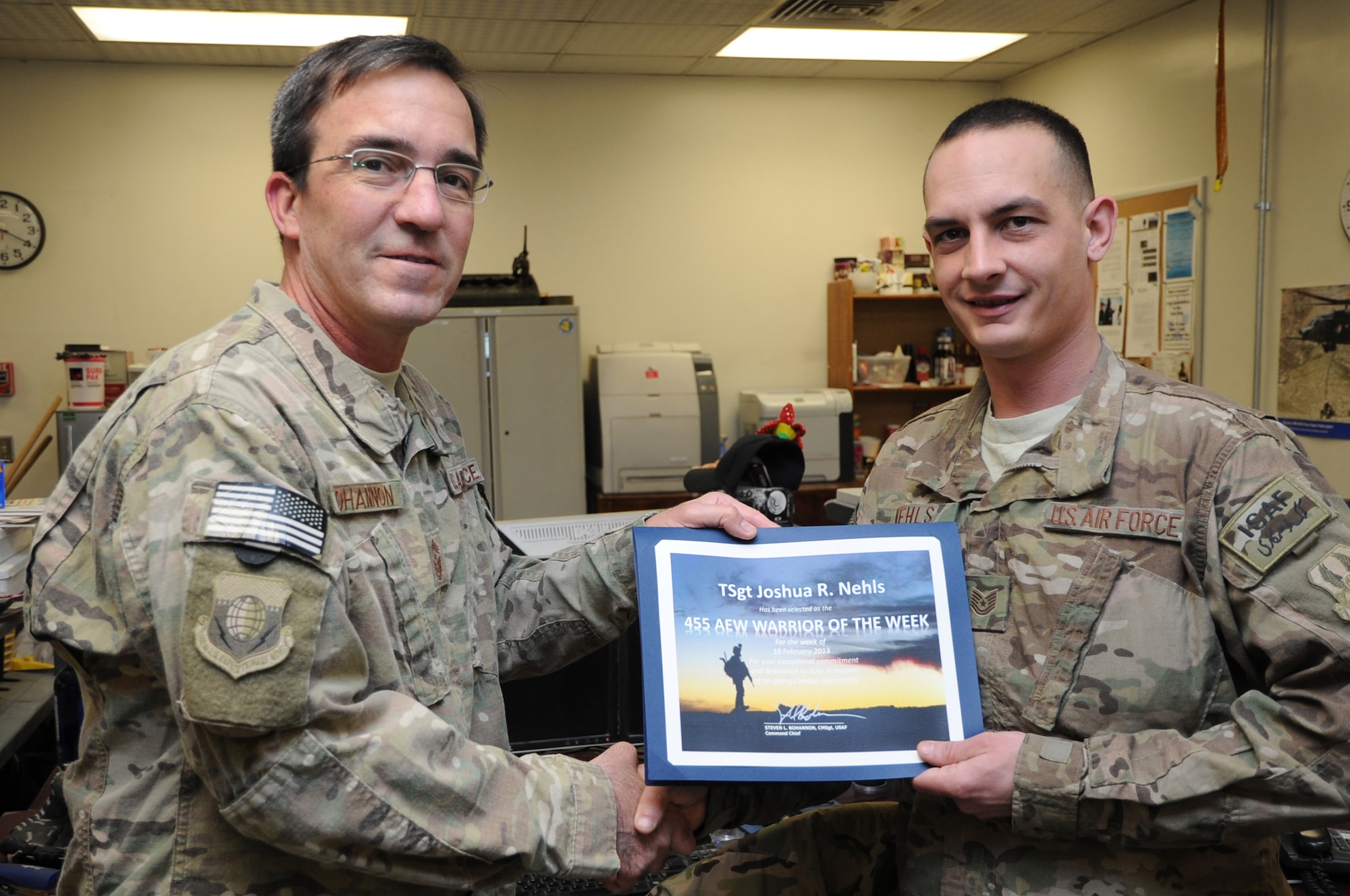 Chief Master Sgt. Steve Bohannon, Command Chief Master Sergeant of the 455th Air Expeditionary Wing, presents the "Warrior of the Week" award Tech. Sgt. Joshua Nehls, 455th Expeditionary Maintenance Group quality assurance chief inspector, on Bagram Airfield, Afghanistan, Feb. 28, 2013. Nehls is responsible for validating the quality of maintenance performed on the A-10 Thunderbolt II aircraft. (U.S. Air Force photo/Staff Sgt. David Dobrydney)