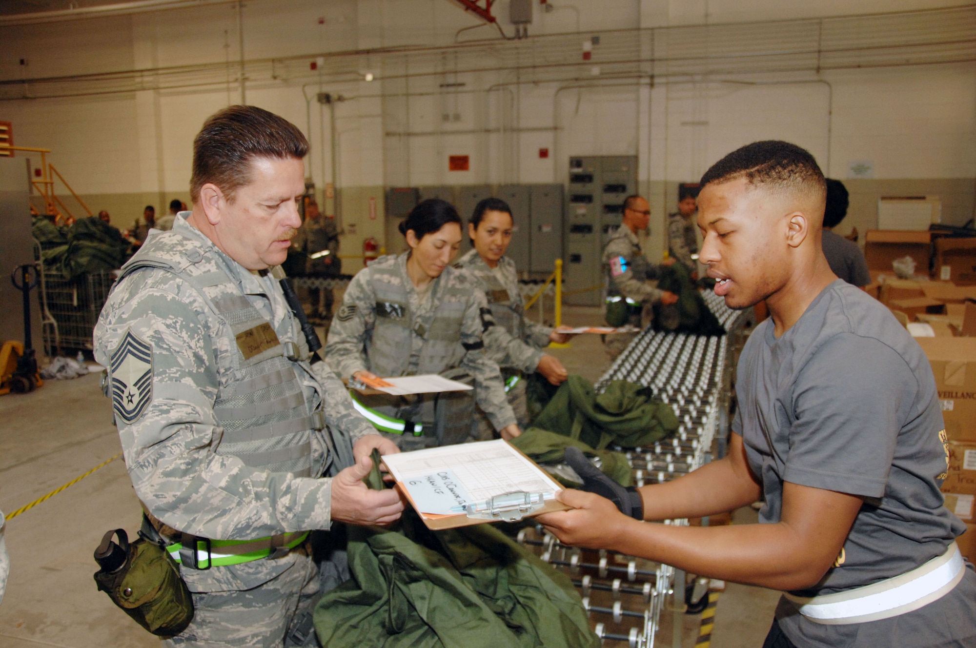 Jamil Montigue, a member of the 146th Airlift Wing's student flight, helps build Chief Master Sgt. Ron O' Conner's mobility bag during a prepare the force exercise for the upcoming ORI (Operational Readiness Inspection) at the 146th Airlift Wing located in Port Hueneme Calif, March 3, 2013. Montigue is scheduled to leave for military basic training May 6, 2013 and upon return will be joining the Logistics Readiness Squadron. (U.S. Air Force photo by: Senior Airman Nicholas Carzis)