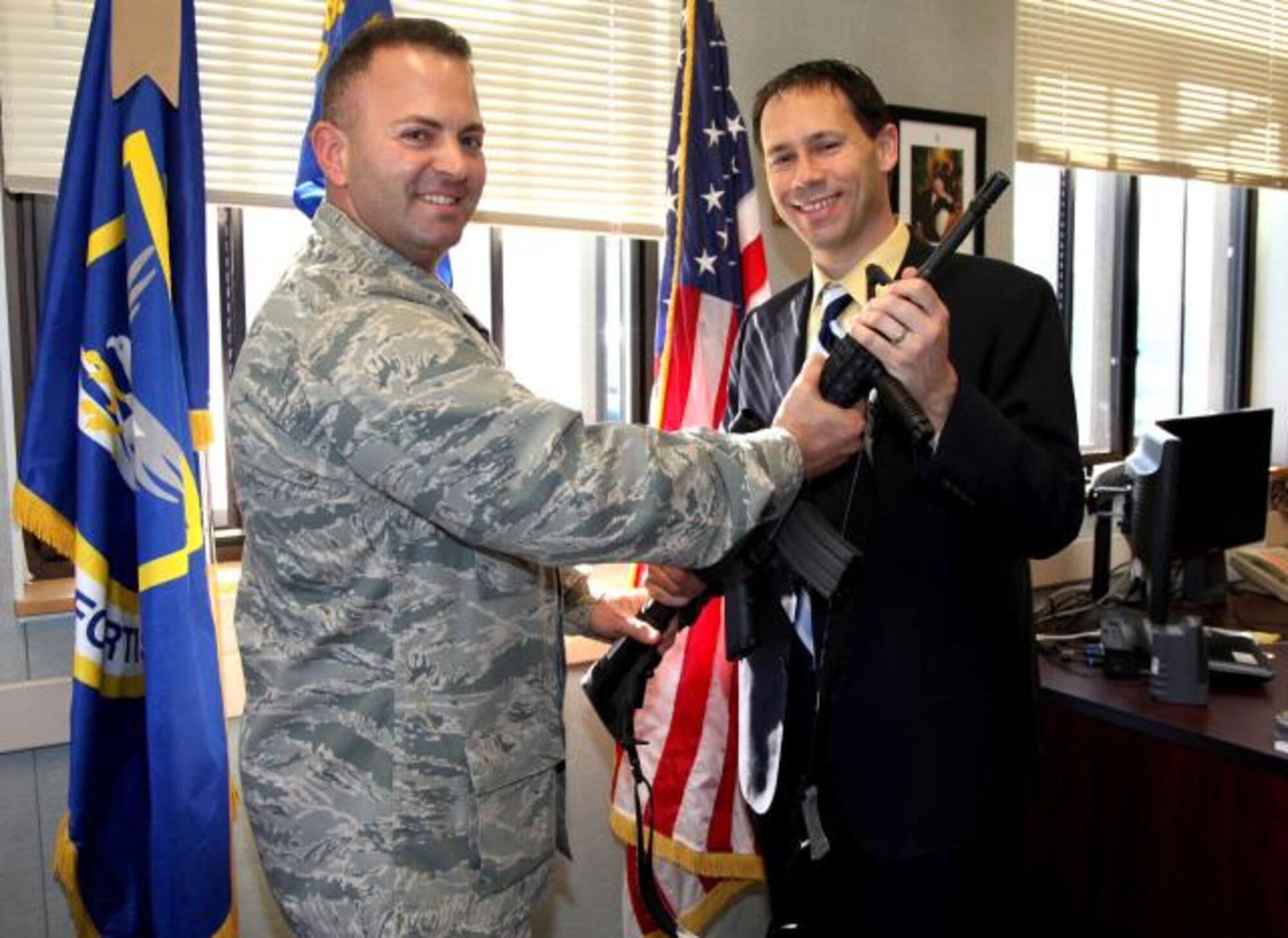 Major Tyson Sorci, 940th Security Forces Squadron Commander, presents an M-4 rifle to Gary Davis, Mayor of Elk Grove, Calif. at Beale Air Force Base, Calif.  Davis was inducted into the 940th Wing’s honorary squadron commander program, along with 5 other civic leaders, March 1. (U.S Air Force Photo/Tech. Sgt. Kenneth McCann)