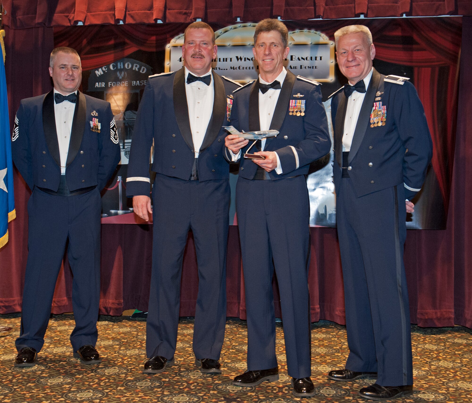 Lt. Col. Pete Buehn (middle right), 446th Operations Group, receives his award for Supervisory Civilian of the Year for the 446th Airlift Wing from Maj. Gen. Mark Kyle (middle left), 4th Air Force Commander, Col. Bruce Bowers, 446th AW Commander (right), and Chief Master Sgt. Tony Mack (left), 446th AW Command Chief, during the 446th's Annual Awards Banquet at the McChord Colocated Club here March 2. Buehn was also recognized as the Air Force Association Outstanding Air Force Civilian Employee in the Civilian Program Manager Category. (U.S. Air Force Photo/ Master Sgt. Eli Yamzon)