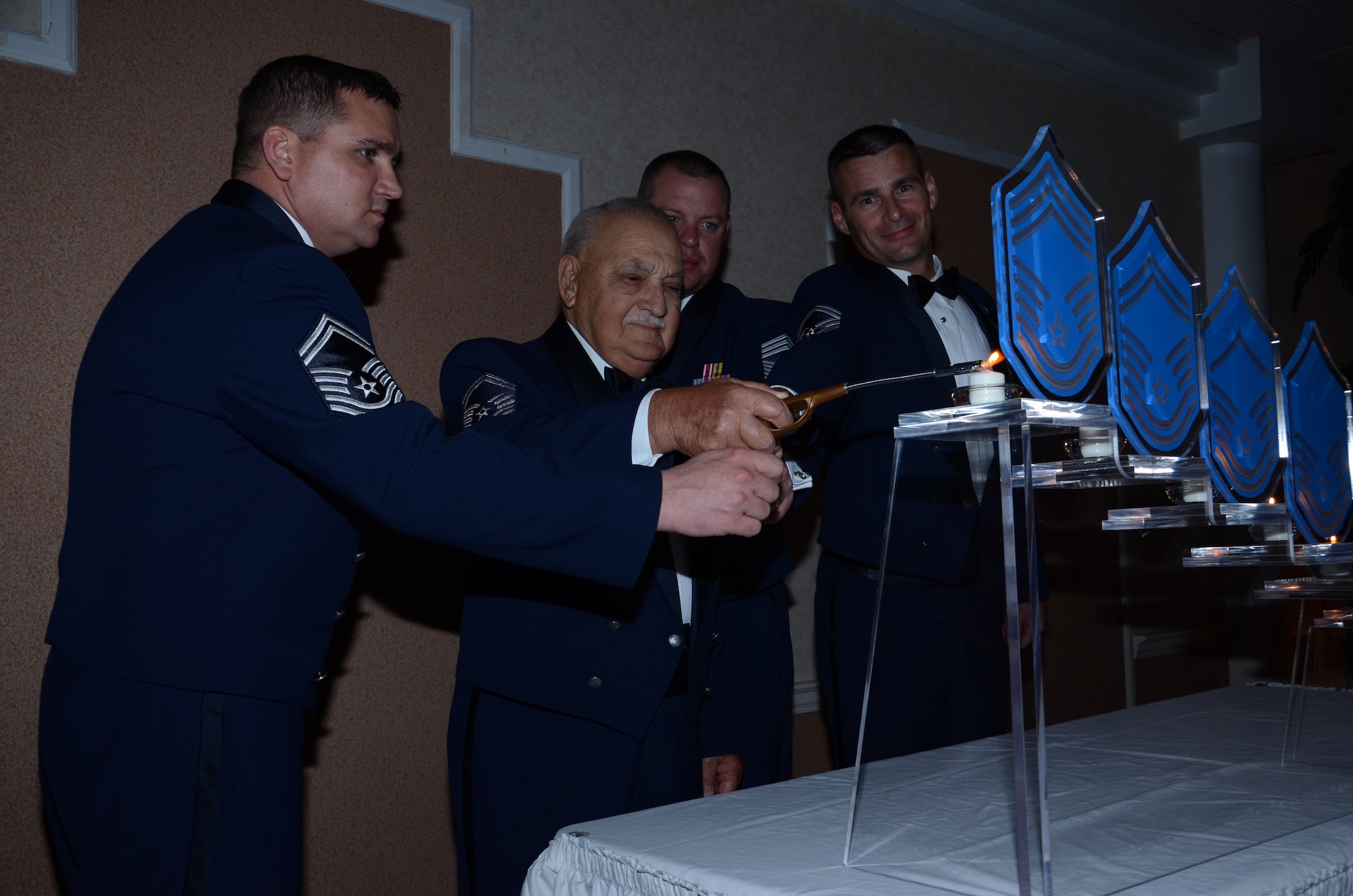 Retired Chief Master Sgt. Joseph Pannitto (center) lights a candle during the Chief's Recognition Ceremony March 2, 2012, in Cocoa Beach, Fla., symbolizing the achievement and honor of earning the highest Air Force enlisted rank.(U.S. Air Force photo/Senior Airman Natasha Dowridge) 