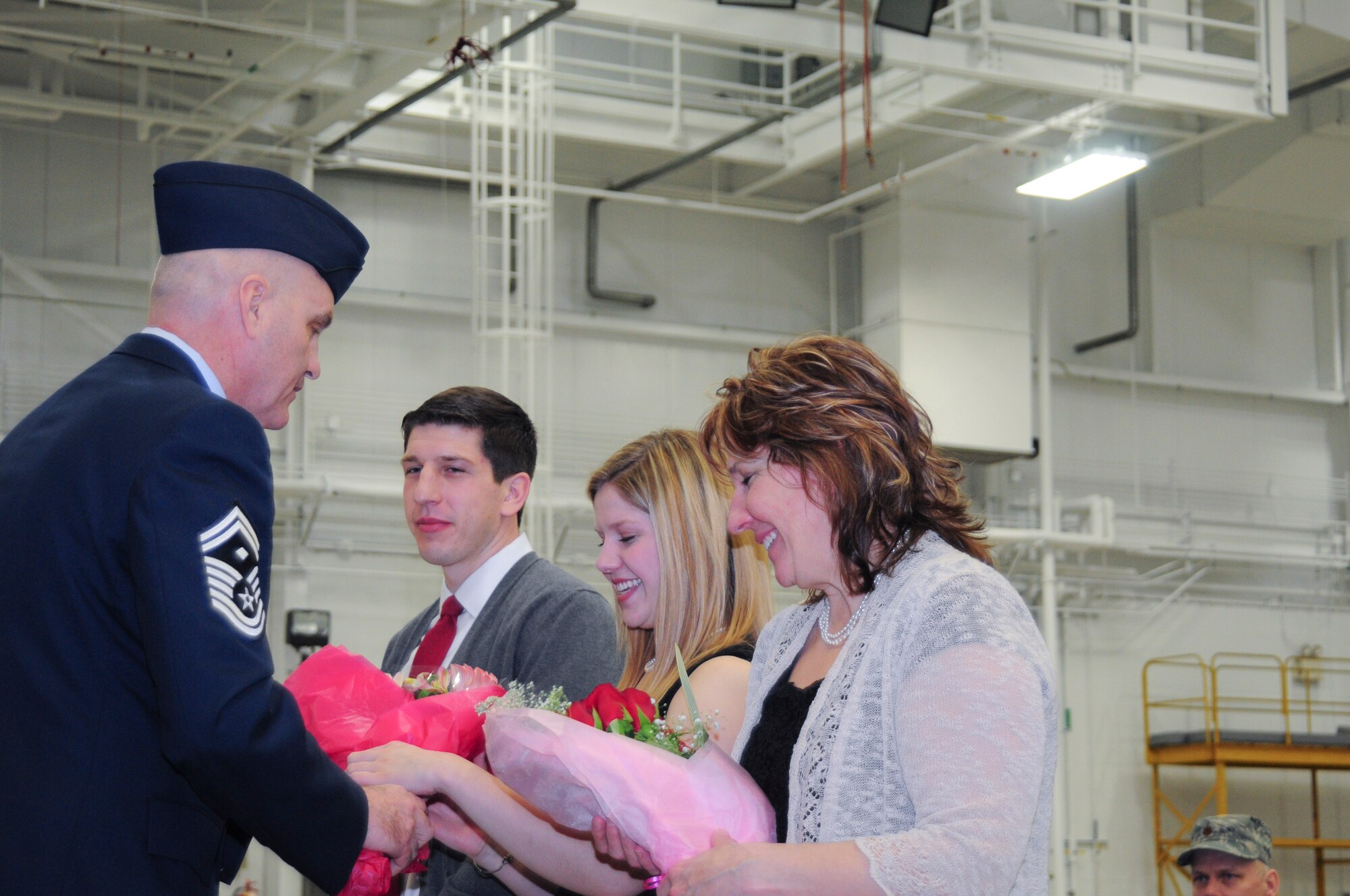 YOUNGSTOWN AIR RESERVE STATION, Ohio – U.S. Air Force Reserve Senior Master Sgt. Douglas Shepard presents family members of Col. David Post’s family with flowers during the 910th Maintenance Group assumption of command ceremony March 2, 2013 here. Post was the incoming MXG commander and began his duties immediately following the ceremony. U.S. Air Force photo by Senior Airman Ron Dombkowski