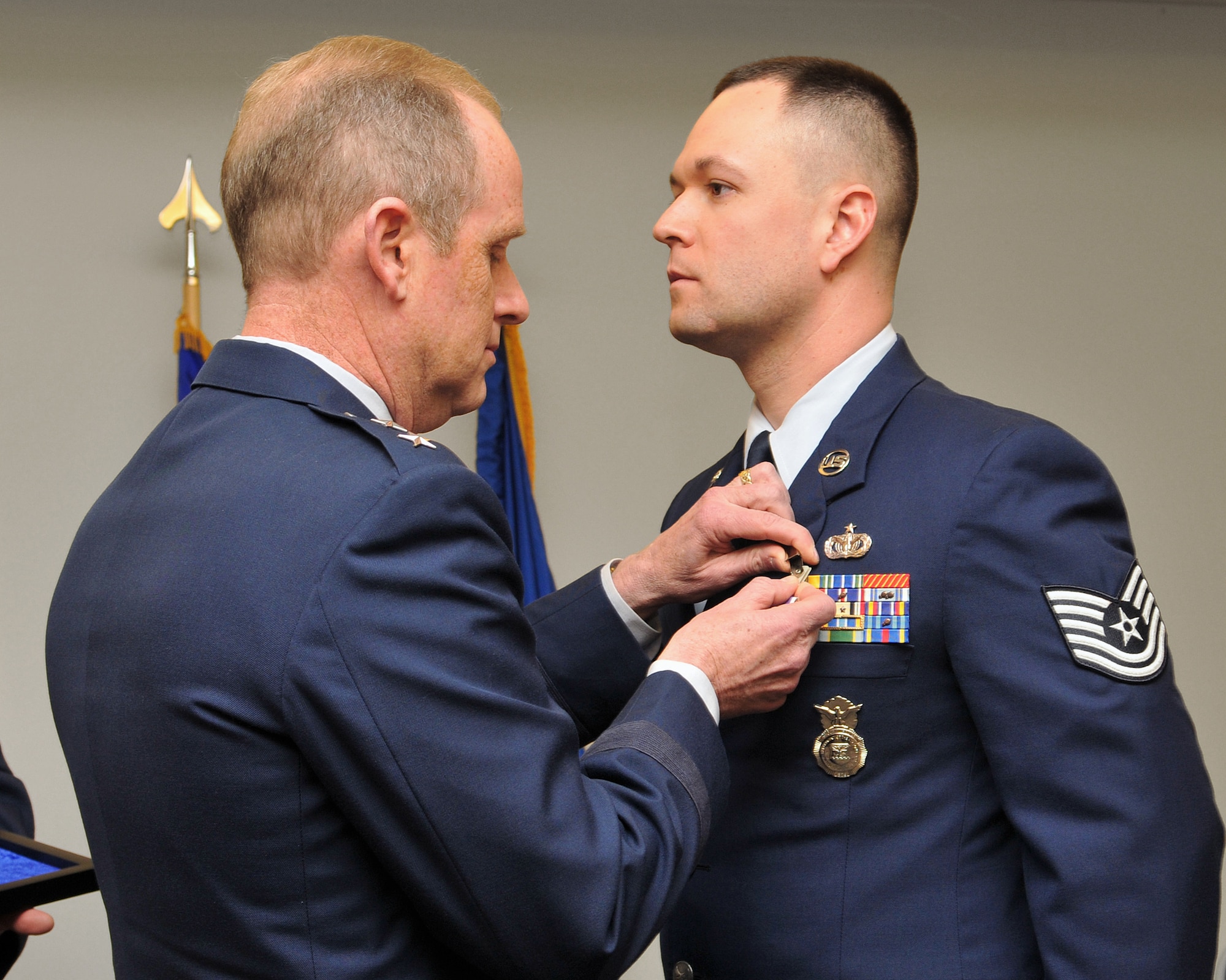 Maj. Gen. Donald P. Dunbar, adjutant general of Wisconsin, presents the Purple Heart to Tech. Sgt. Cristian A. Bennett, 115th Fighter Wing assistant program security manager, during a ceremony in Madison, Wis., Feb. 4. Bennett received the medal for injuries received when his Humvee was struck by an improvised explosive device during a security escort mission in Iraq on Feb. 24, 2006.  