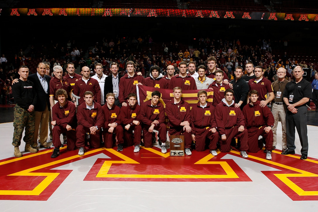 Officer Selection Station Twin Cities poses with University of Minnesota wrestlers following the NWCA National Duals at Williams Arena Feb. 23. The U of M wrestling team won the Division I title. Capt. Andrew Schroers and Gunnery Sgt. Roland McGinnis presented awards to the top four teams at the meet. 