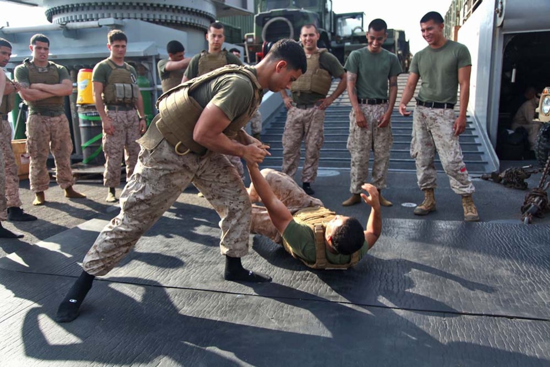 Marines assigned to the 15th Marine Expeditionary Unit practice movements from the Marine Corps Martial Arts Program aboard USS Rushmore, Feb. 21. While away, servicemembers find many ways to pass time while improving themselves and others physically, mentally and professionally.  The 15th MEU is deployed as part of the Peleliu Amphibious Ready Group as a U.S. Central Command theater reserve force, providing support for maritime security operations and theater security cooperation efforts in the U.S. 5th Fleet area of responsibility. (U.S. Marine Corps photo by Cpl. Timothy R. Childers/ Released)