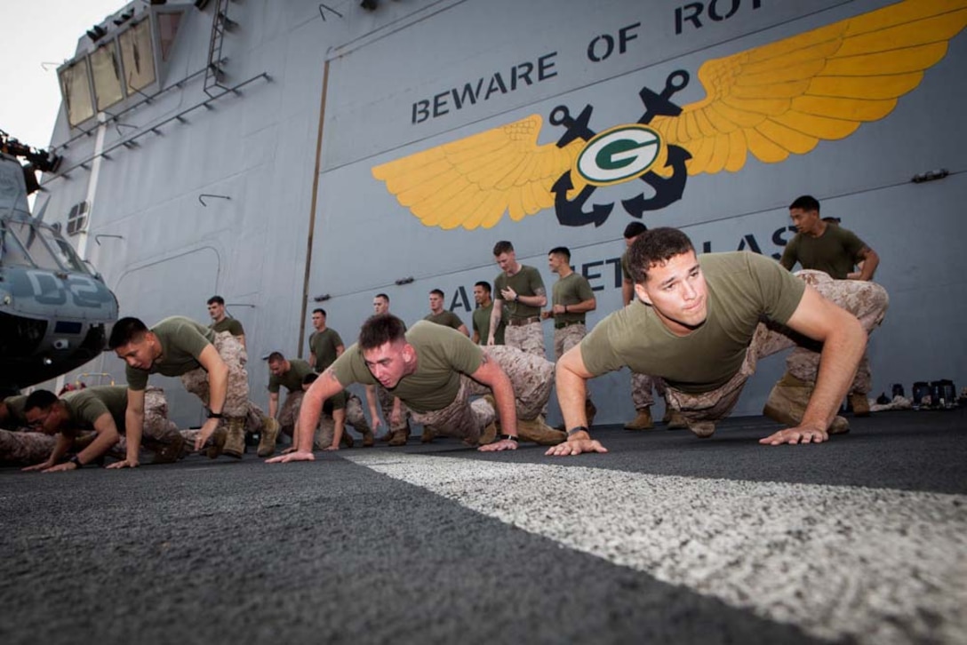 Marines with the 15th Marine Expeditionary Unit warm up before training during Corporals' Course aboard the USS Green Bay, Feb. 26. Corporals' Course is professional military education for enlisted Marines designed to give them the tools to become effective small unit leaders. The 15th MEU is deployed as part of the Peleliu Amphibious Ready Group as a U.S. Central Command theater reserve force, providing support for maritime security operations and theater security cooperation efforts in the U.S. 5th Fleet area of responsibility. (U.S. Marine Corps photo by Cpl. Bobby J. Gonzalez/Released)