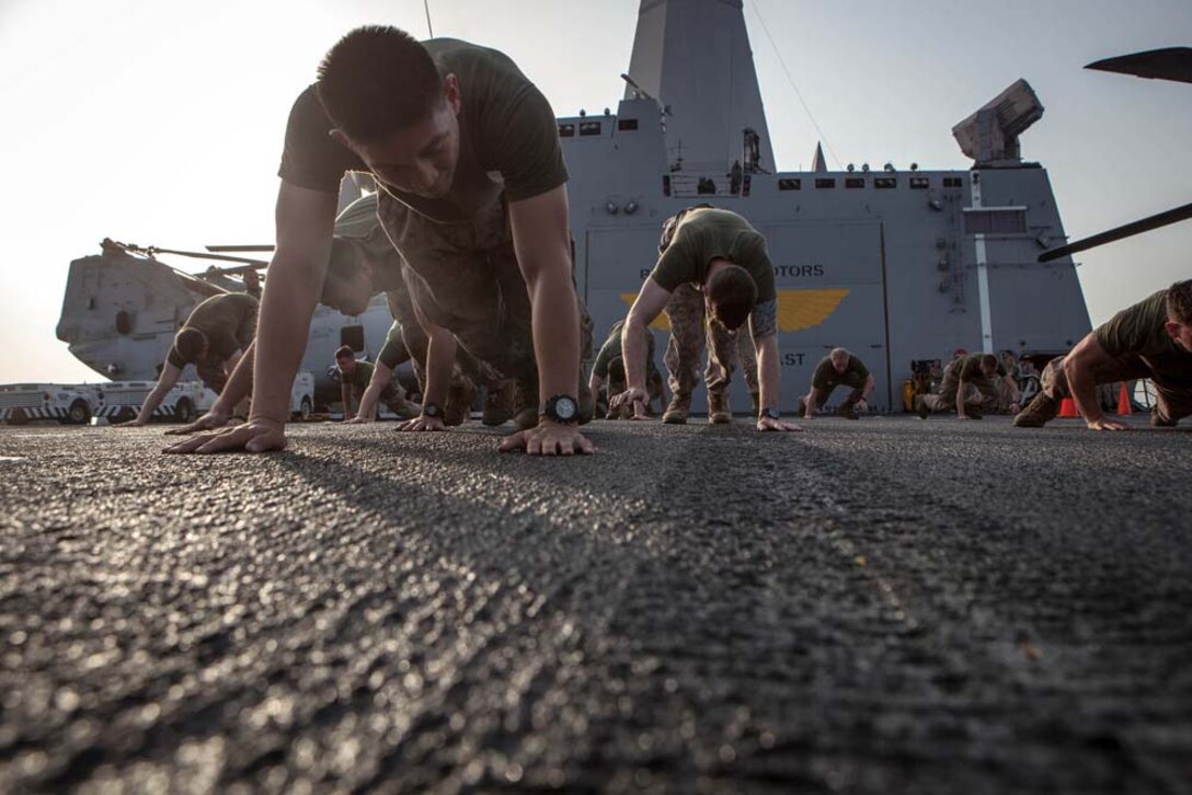 Marines with the 15th Marine Expeditionary Unit warm up before training during Corporals' Course aboard the USS Green Bay, Feb. 26. Corporals' Course is professional military education for enlisted Marines designed to give them the tools to become effective small unit leaders. The 15th MEU is deployed as part of the Peleliu Amphibious Ready Group as a U.S. Central Command theater reserve force, providing support for maritime security operations and theater security cooperation efforts in the U.S. 5th Fleet area of responsibility. (U.S. Marine Corps photo by Cpl. Bobby J. Gonzalez/Released)