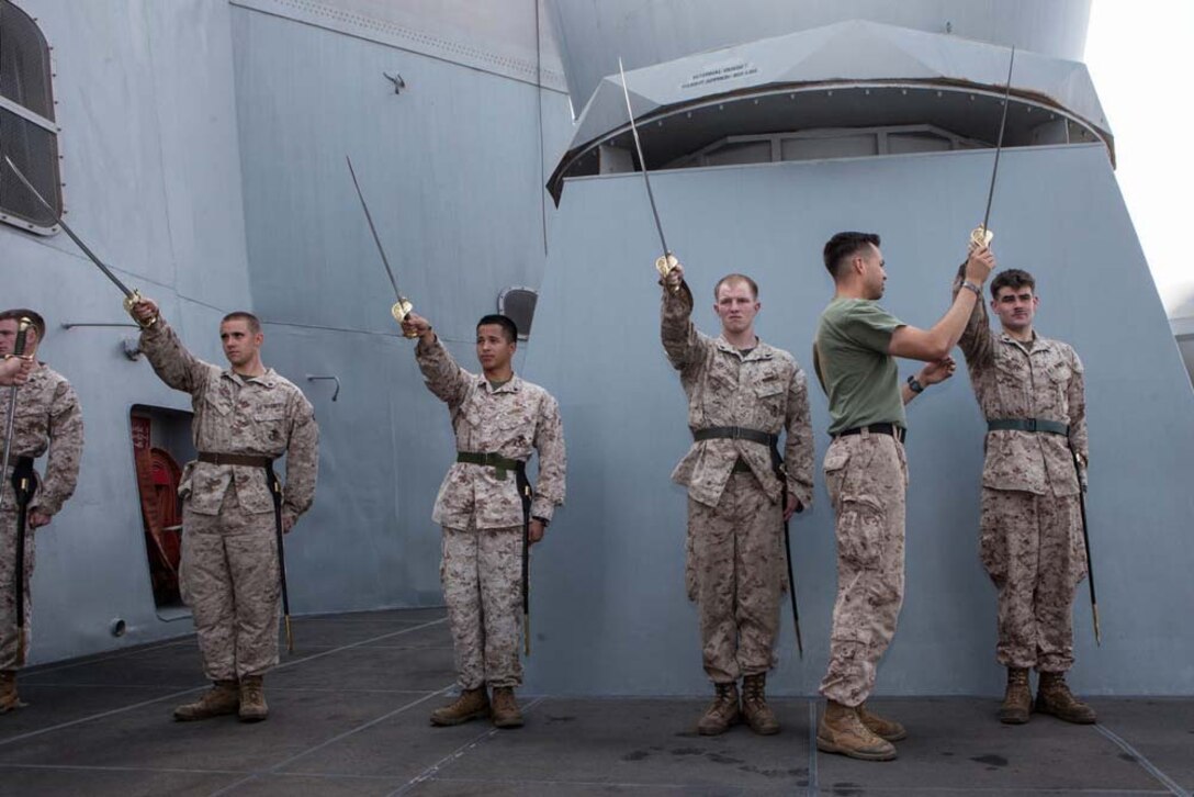 Marines with the 15th Marine Expeditionary Unit learn sword manual during Corporals' Course aboard the USS Green Bay, Feb. 26. Corporals' Course is professional military education for enlisted Marines designed to give them the tools to become effective small unit leaders. The 15th MEU is deployed as part of the Peleliu Amphibious Ready Group as a U.S. Central Command theater reserve force, providing support for maritime security operations and theater security cooperation efforts in the U.S. 5th Fleet area of responsibility. (U.S. Marine Corps photo by Cpl. Bobby J. Gonzalez/Released)