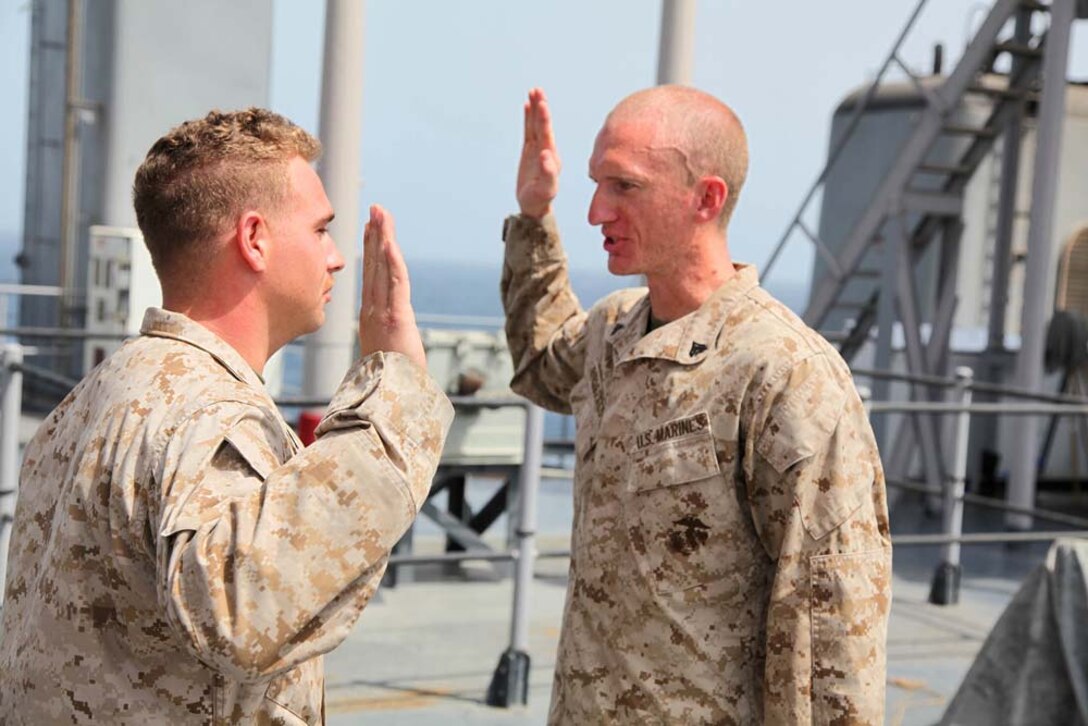 Corporal Joseph F. Bielefeldt (right), landing support specialist, Transportation Support Detachment, Combat Logistics Battalion 15, 15th Marine Expeditionary Unit, cites the Non-Commissioned Officer's Creed after being promoted to the rank of corporal aboard USS Rushmore, March 1. The 15th MEU is deployed as part of the Peleliu Amphibious Ready Group as a U.S. Central Command theater reserve force, providing support for maritime security operations and theater security cooperation efforts in the U.S. 5th Fleet area of responsibility. (U.S. Marine Corps photo by Cpl. Timothy R. Childers/Released)