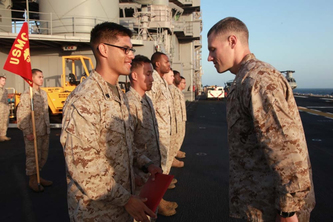 Newly promoted Sgt. Henry E. Cisneros, company clerk, Headquarters and Service Company, Battalion Landing Team 3/5, 15th Marine Expeditionary Unit, thanks Capt. Braxton Mashburn, his commanding officer, after receiving his new rank on the flight deck of the USS Peleliu, March 1. The 15th MEU is deployed as part of the Peleliu Amphibious Ready Group as a U.S. Central Command theater reserve force, providing support for maritime security operations and theater security cooperation efforts in the U.S. 5th Fleet area of responsibility. Cisneros, 21, is from Palmdale, Calif. (U.S. Marine Corps photo by Cpl. John Robbart III/Released)