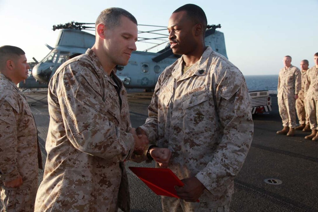 Newly promoted Sgt. Lynnjoey J. Terry, motor transport mechanic, Headquarters and Service Company, Battalion Landing Team 3/5, 15th Marine Expeditionary Unit, shakes hands with Capt. Braxton Mashburn, his commanding officer, after receiving his new rank on the flight deck of the USS Peleliu, March 1. The 15th MEU is deployed as part of the Peleliu Amphibious Ready Group as a U.S. Central Command theater reserve force, providing support for maritime security operations and theater security cooperation efforts in the U.S. 5th Fleet area of responsibility. Terry, 23, is from Memphis, Tenn. (U.S. Marine Corps photo by Cpl. John Robbart III/Released)
