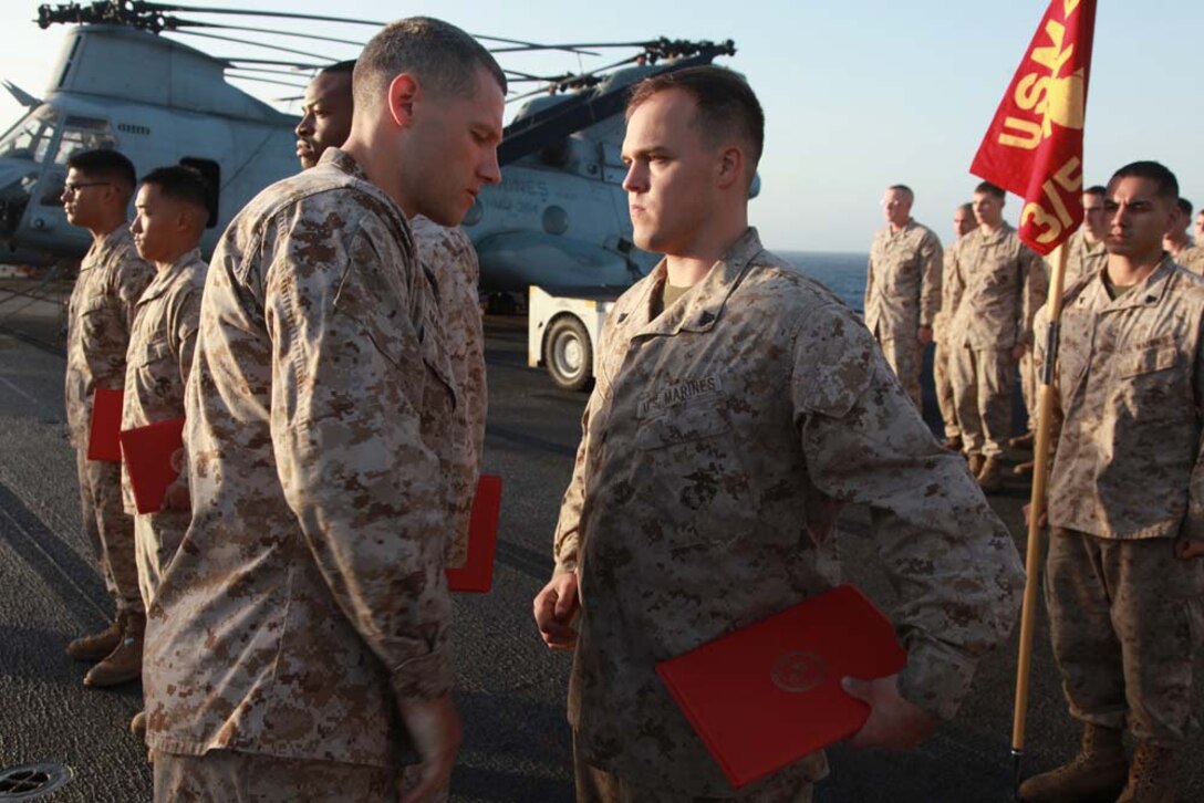Newly promoted Corporal Christopher S. Loudermilk, field radio operator, Headquarters and Service Company, Battalion Landing Team 3/5, 15th Marine Expeditionary Unit, receives his promotion warrant from Capt. Braxton Mashburn, his commanding officer, after receiving his new rank on the flight deck of the USS Peleliu, March 1. The 15th MEU is deployed as part of the Peleliu Amphibious Ready Group as a U.S. Central Command theater reserve force, providing support for maritime security operations and theater security cooperation efforts in the U.S. 5th Fleet area of responsibility. Loudermilk, 22, is from Scottsboro, Ala. (U.S. Marine Corps photo by Cpl. John Robbart III/Released)