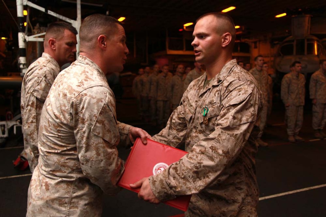Sergeant Billy R. Couch, low-altitude air-defense gunner, Marine Medium Helicopter Squadron 364 (Rein.), 15th Marine Expeditionary Unit, receives the citation for his Navy and Marine Corps Achievement Medal from Lt. Col. Ned M. Biehl, his commanding officer, in the hangar bay of the USS Peleliu, March 1. The 15th MEU is deployed as part of the Peleliu Amphibious Ready Group as a U.S. Central Command theater reserve force, providing support for maritime security operations and theater security cooperation efforts in the U.S. 5th Fleet area of responsibility. Couch, 25, is from Indianapolis, Ind. (U.S. Marine Corps photo by Cpl. John Robbart III/Released)