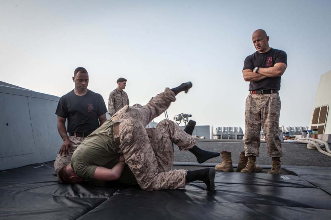 Marines with the 15th Marine Expeditionary Unit participate in a grappling match during Corporals' Course aboard the USS Green Bay, Feb. 26. Corporals' Course is professional military education for enlisted Marines designed to give them the tools to become effective small unit leaders. The 15th MEU is deployed as part of the Peleliu Amphibious Ready Group as a U.S. Central Command theater reserve force, providing support for maritime security operations and theater security cooperation efforts in the U.S. 5th Fleet area of responsibility. (U.S. Marine Corps photo by Cpl. Bobby J. Gonzalez/Released)