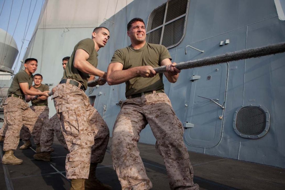 Marines with the 15th Marine Expeditionary Unit participate in tug-of-war during Corporals' Course aboard the USS Green Bay, Feb. 26. Corporals' Course is professional military education for enlisted Marines designed to give them the tools to become effective small unit leaders. The 15th MEU is deployed as part of the Peleliu Amphibious Ready Group as a U.S. Central Command theater reserve force, providing support for maritime security operations and theater security cooperation efforts in the U.S. 5th Fleet area of responsibility. (U.S. Marine Corps photo by Cpl. Bobby J. Gonzalez/Released)