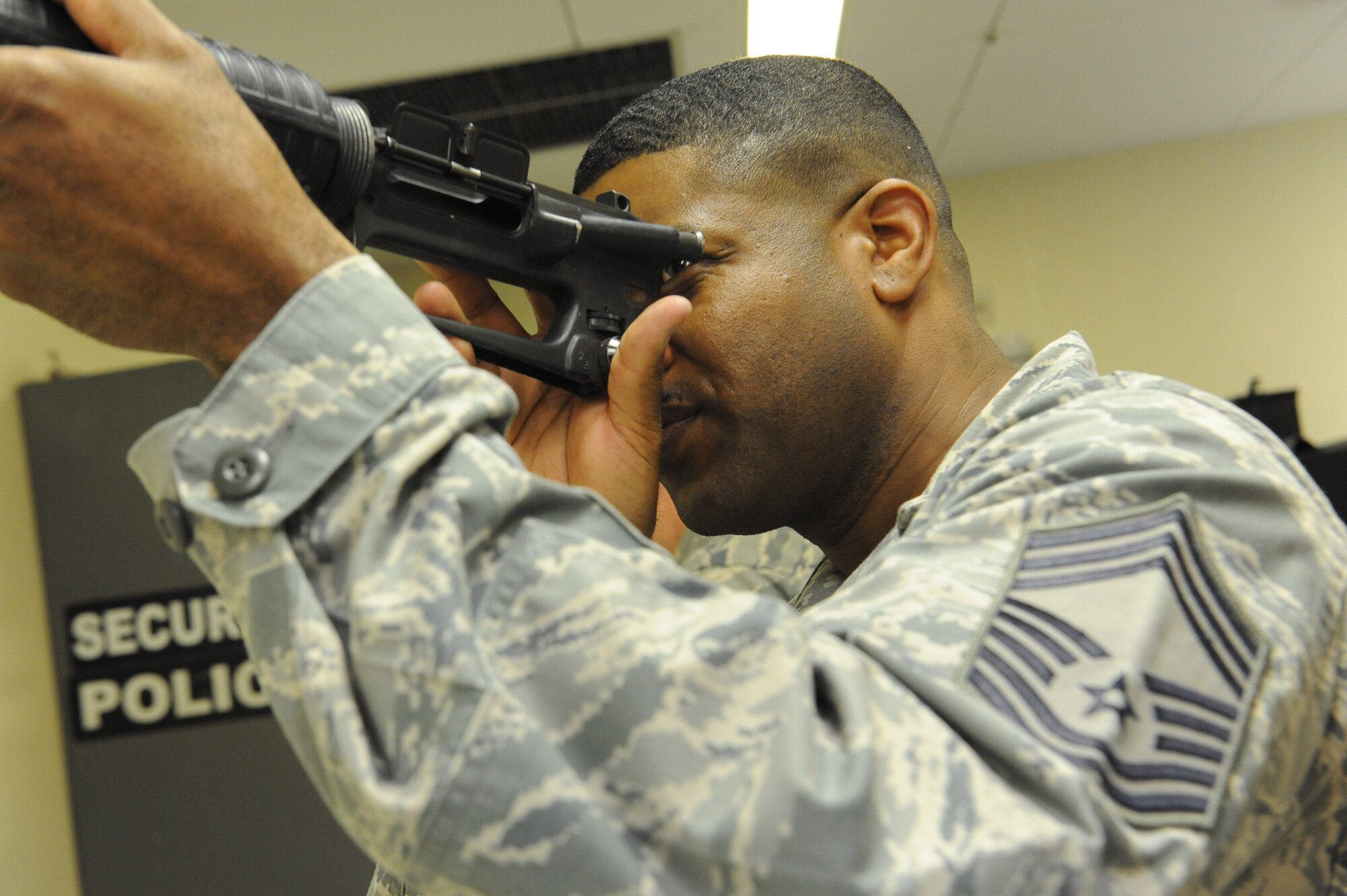 U.S. Air Force Chief Master Sgt. Phillip Easton, 18th Mission Support Group superintendent, inspects the barrel of a weapon at the 18th Security Forces Squadron on Kadena Air Base, Japan, Feb. 28, 2013. During his visit to the squadron, he was shown how to take a weapon apart and put it back together and the cleaning process security forces members go through to ensure the weapon is serviceable. Easton and Col. Jeff Ullmann, 18th MSG commander, visit squadrons within their command once a week to experience what their Airmen do on a daily basis as part of the 18th MSG work program. (U.S. Air Force photo/Airman 1st Class Malia Jenkins)