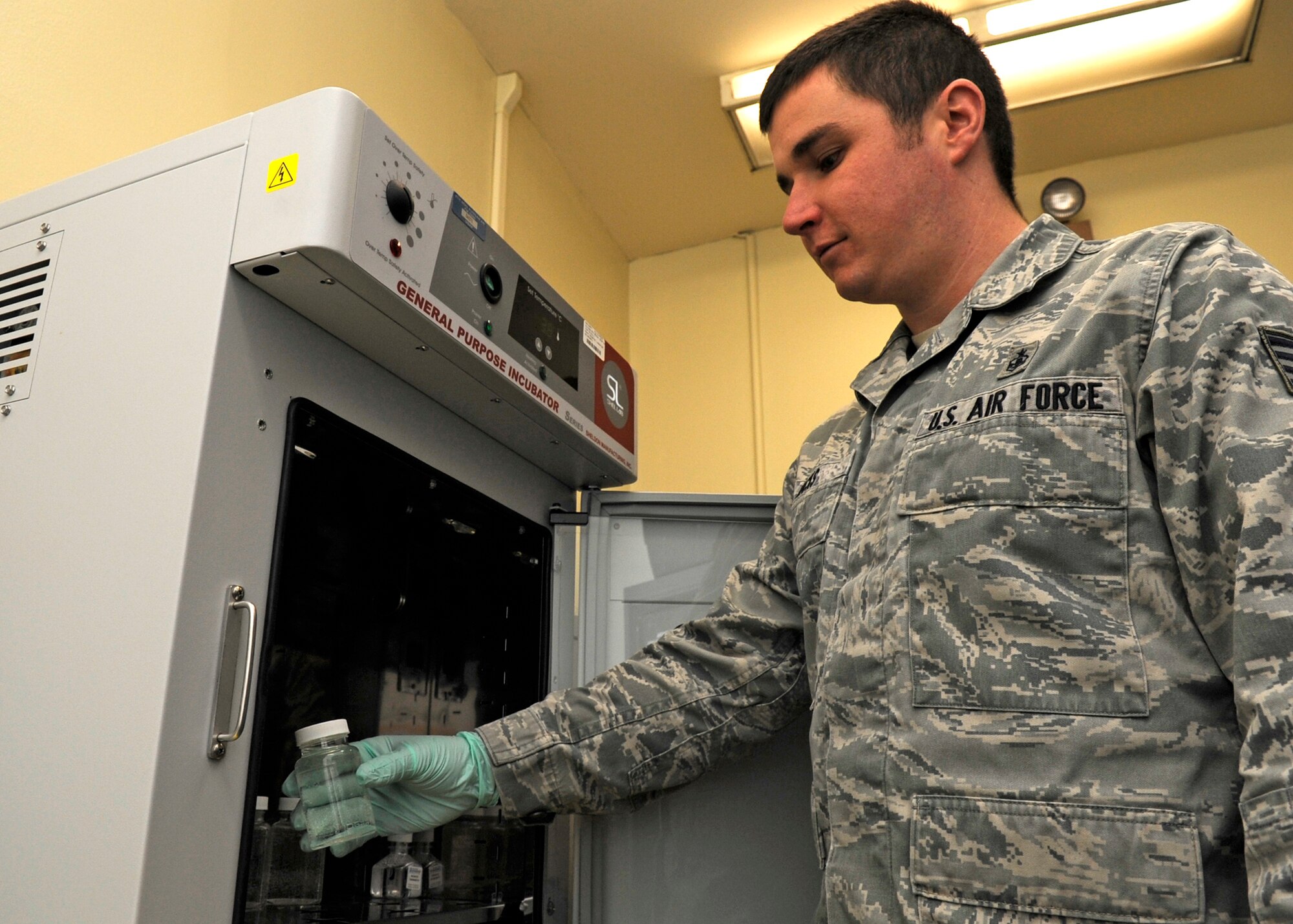 KUNSAN AIR BASE, Republic of Korea – Staff Sgt. Kyle Hicks, 8th Medical Operation Squadron Bioenvironmental Engineering craftsman pulls a water sample collected the day prior, from an incubator Feb. 19 2013. All samples require 24 hour incubation and colilert mixed in, a growth medium for bacteria; to give contaminates the most ideal conditions for growth. (U.S. Air Force photo Staff Sgt. Tong Duong)