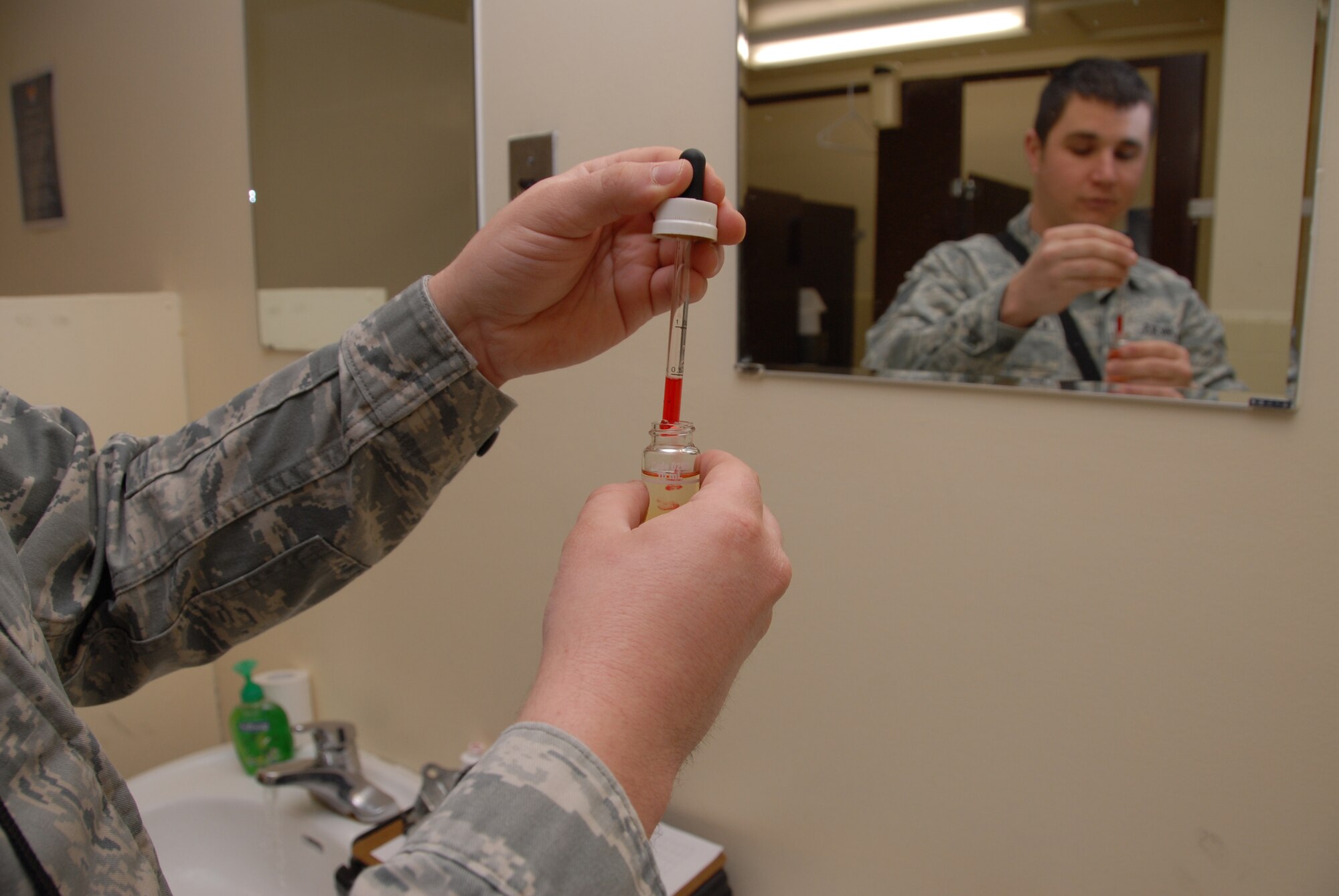 KUNSAN AIR BASE, Republic of Korea – Staff Sgt. Kyle Hicks, 8th Medical Operation Squadron Bioenvironmental Engineering craftsman drops phenol red into a water sample collected from building 1305, Feb. 20 2013. Phenol red is a red dye used as a pH indicator to show acidity of a water sample. Each month, Hicks collects water samples from eight different areas around the base to test. (U.S. Air Force photo Staff Sgt. Tong Duong) 