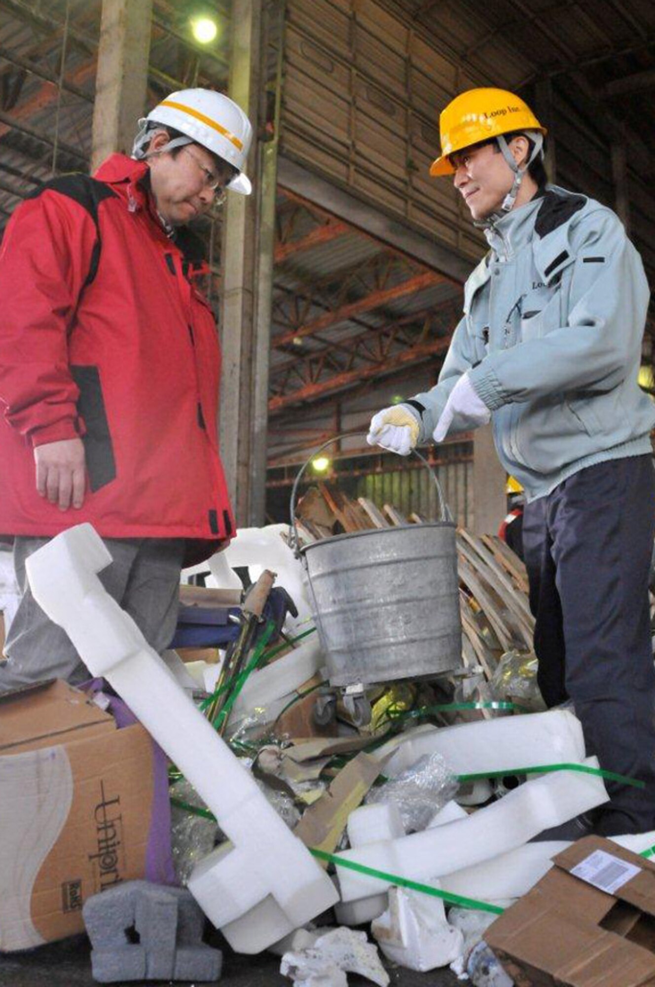 Haruhito Ishixuka, Hosoya Disposal Site Misawa Air Base trash manager, right, points at a metal bucket found in a bulk trash delivery as Hajime Sasaki, 35th Civil Engineer Squadron solid waste manager, looks on in Misawa City, Japan, Feb. 28, 2013. The chief complaint of the Hosoya Disoposal Site is recyclables being mixed with bulk waste. Hosoya is the final stop for all of the base’s trash and recyclables. (U.S. Air Force photo by Tech. Sgt. Phillip Butterfield) 