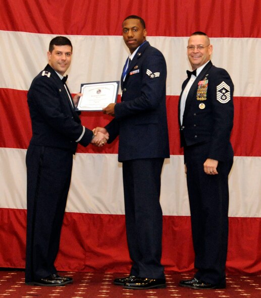 Senior Airman James Coleman, 2nd Maintenance Squadron, receives an Airman Leadership Graduation certificate from Col. Andrew Gebara, 2nd Bomb Wing commander, on Barksdale Air Force Base, La., Feb. 7. (U.S. Air Force photo/Airman 1st Class Andrew Moua)