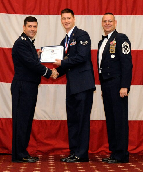Senior Airman Marcus Martin, 2nd Civil Engineer Squadron, receives an Airman Leadership Graduation certificate from Col. Andrew Gebara, 2nd Bomb Wing commander, on Barksdale Air Force Base, La., Feb. 7. (U.S. Air Force photo/Airman 1st Class Andrew Moua)