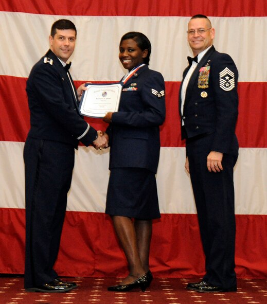 Senior Airman Cedric Johnson, 2nd Force Support Squadron, receives an Airman Leadership Graduation certificate from Col. Andrew Gebara, 2nd Bomb Wing commander, on Barksdale Air Force Base, La., Feb. 7. (U.S. Air Force photo/Airman 1st Class Andrew Moua)