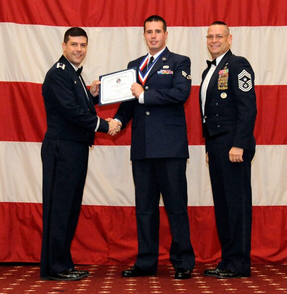 Senior Airman Dustin Huskins, 2nd Maintenance Squadron, receives an Airman Leadership Graduation certificate from Col. Andrew Gebara, 2nd Bomb Wing commander, on Barksdale Air Force Base, La., Feb. 7. (U.S. Air Force photo/Airman 1st Class Andrew Moua)