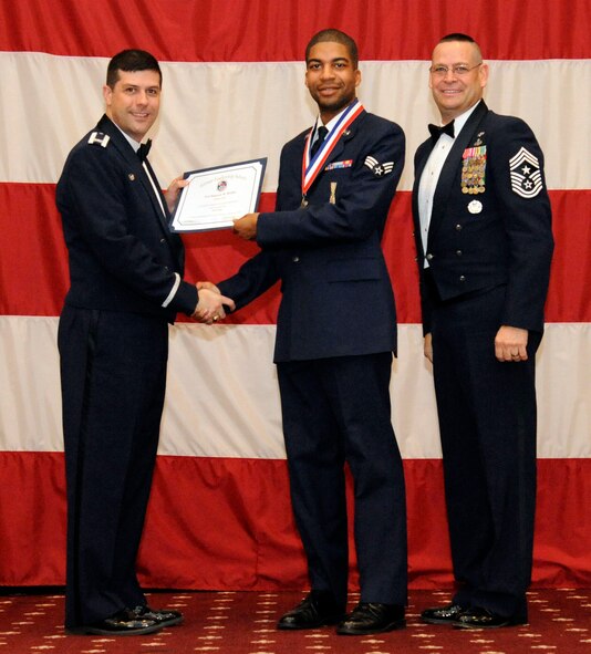 Senior Airman Saquan Holder, 2nd Munitions Squadron, receives an Airman Leadership Graduation certificate from Col. Andrew Gebara, 2nd Bomb Wing commander, on Barksdale Air Force Base, La., Feb. 7. (U.S. Air Force photo/Airman 1st Class Andrew Moua)