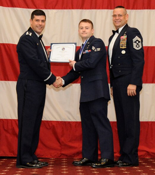 Senior Airman Tyler Dove, 26th Operational Weather Squadron, receives an Airman Leadership Graduation certificate from Col. Andrew Gebara, 2nd Bomb Wing commander, on Barksdale Air Force Base, La., Feb. 7. (U.S. Air Force photo/Airman 1st Class Andrew Moua)