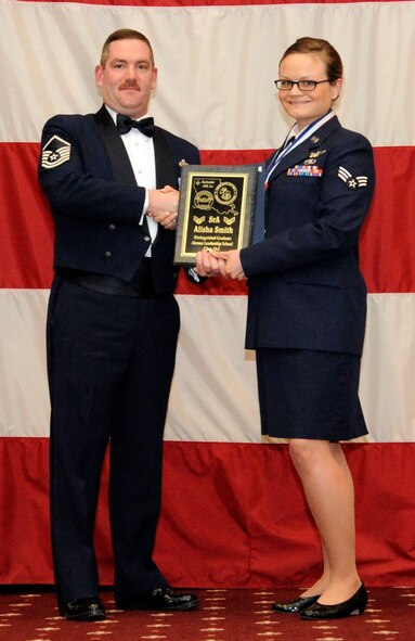 Senior Airman Alisha Smith, 2nd Bomb Wing Chaplain Assistant, receives the Distinguished Graduate Award from Master Sgt. Jason Hurley, Air Force Global Strike Command, during the Airman Leadership School Class 13-2 Graduation on Barksdale Air Force Base, La., Feb. 7. (U.S. Air Force photo/Airman 1st Class Andrew Moua)