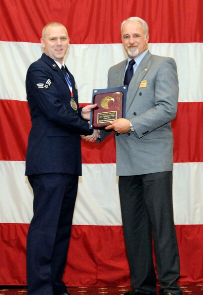 Senior Airman Nathaniel Wing, 2nd Munitions Squadron, receives the Academic Award from Bill Mesloh, Embry Riddle Aeronautical University, during the Airman Leadership School Class 13-2 Graduation on Barksdale Air Force Base, La., Feb. 7. (U.S. Air Force photo/Airman 1st Class Andrew Moua)