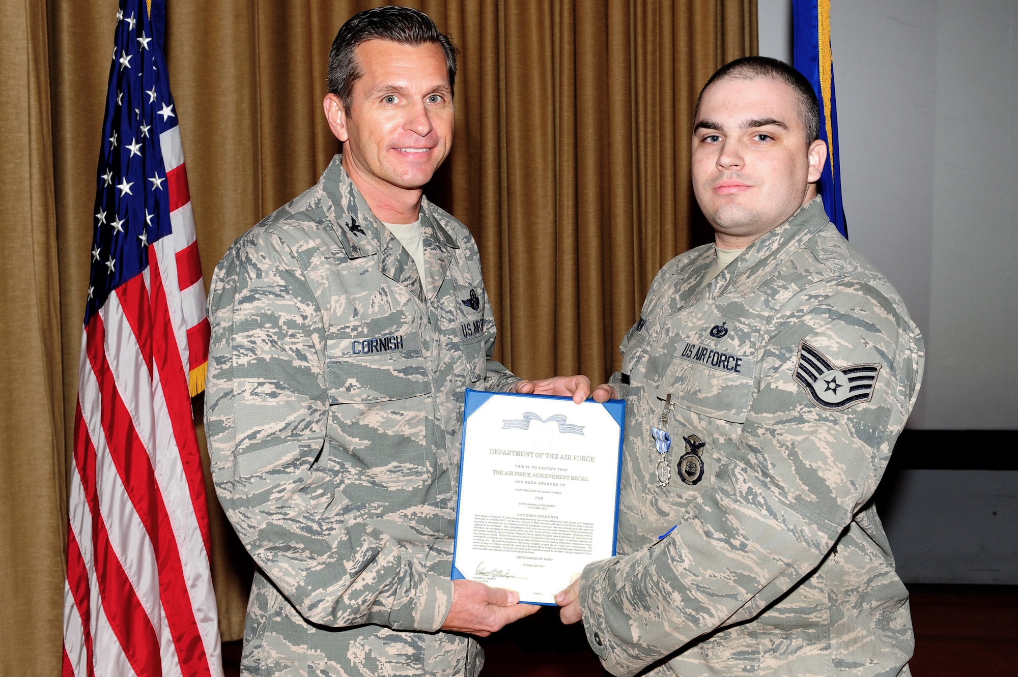 U.S. Air Force Col. Barry Cornish, 99th Air Base Wing commander, presents Staff Sgt. William O'Brien, 99th Security Forces Squadron security forces craftsman, with the Air Force Achievement Medal March 1, 2013 at Nellis Air Force Base, Nev. Staff Sgt. O'Brien was awarded the Air Force Achievement Medal for identifying an Airman with a life threatening condition and rushing him to the Mike O'Callaghan Federal Medical Center. (U.S. Air Force photo by Staff Sgt. William P. Coleman)