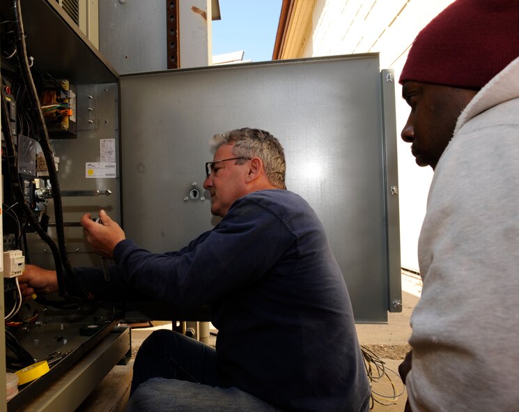 Ray O'Briant, 2nd Civil Engineer Squadron Heating, Ventilation, Air Conditioning, and Refrigeration, modifies the power supply of a newly installed chiller as Ricky Ball, 2 CES HVAC/R observes on Barksdale Air Force Base, La., March 1. The HVAC/R's responsibilities include climate control for buildings and maintenance and repair of heating and cooling units. (U.S. Air Force photo/Airman 1st Class Andrew Moua)
