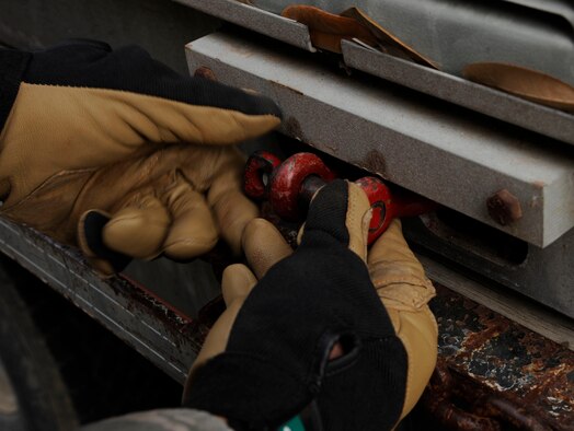 Airman 1st Class Nathan Jarvis, 2nd Civil Engineer Squadron Heating, Ventilation, Air Conditioning, and Refrigeration, tightens a bolt used to secure straps onto a chiller on Barksdale Air Force Base, La., March 1. An old chilling unit was removed and replaced in a joint effort between the HVAC/R and 2 CES Heavy Repair sections. The old chilling unit was removed and salvaged for spare parts and then sold for scrap. (U.S. Air Force photo/Airman 1st Class Andrew Moua)