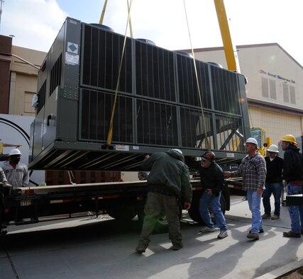 Workers assigned to the 2nd Civil Engineer Squadron Heavy Repair section, inspect a chilling unit prior to installation on Barksdale Air Force Base, La., March 1. The heavy repair section worked with the 2 CES heating, ventilation, air conditioning and refrigeration section to remove an old air conditioning unit and replace it with a new one. (U.S. Air Force photo/Airman 1st Class Andrew Moua)
