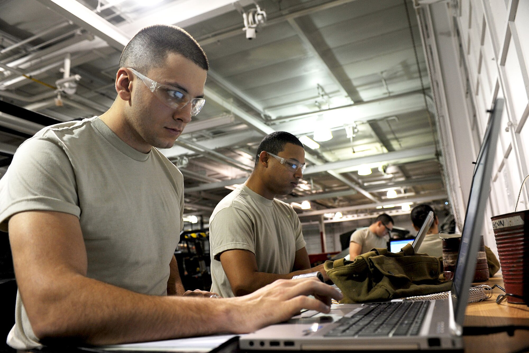 (From left) U.S. Air Force Airman 1st Class Jonathan Haney and Airman Esrick Hamilton, technical training students assigned to the U.S. Army's 2nd Battalion, 210th Aviation Regiment, research information via electronic manuals during training at Fort Eustis, Va., Feb. 20, 2013. The Airmen are part of B Company's Interservice Training Review Organization, which provides H-60 helicopter training for more than 100 Airmen annually. (U.S. Air Force photo by Staff Sgt. Ashley Hawkins/Released) 